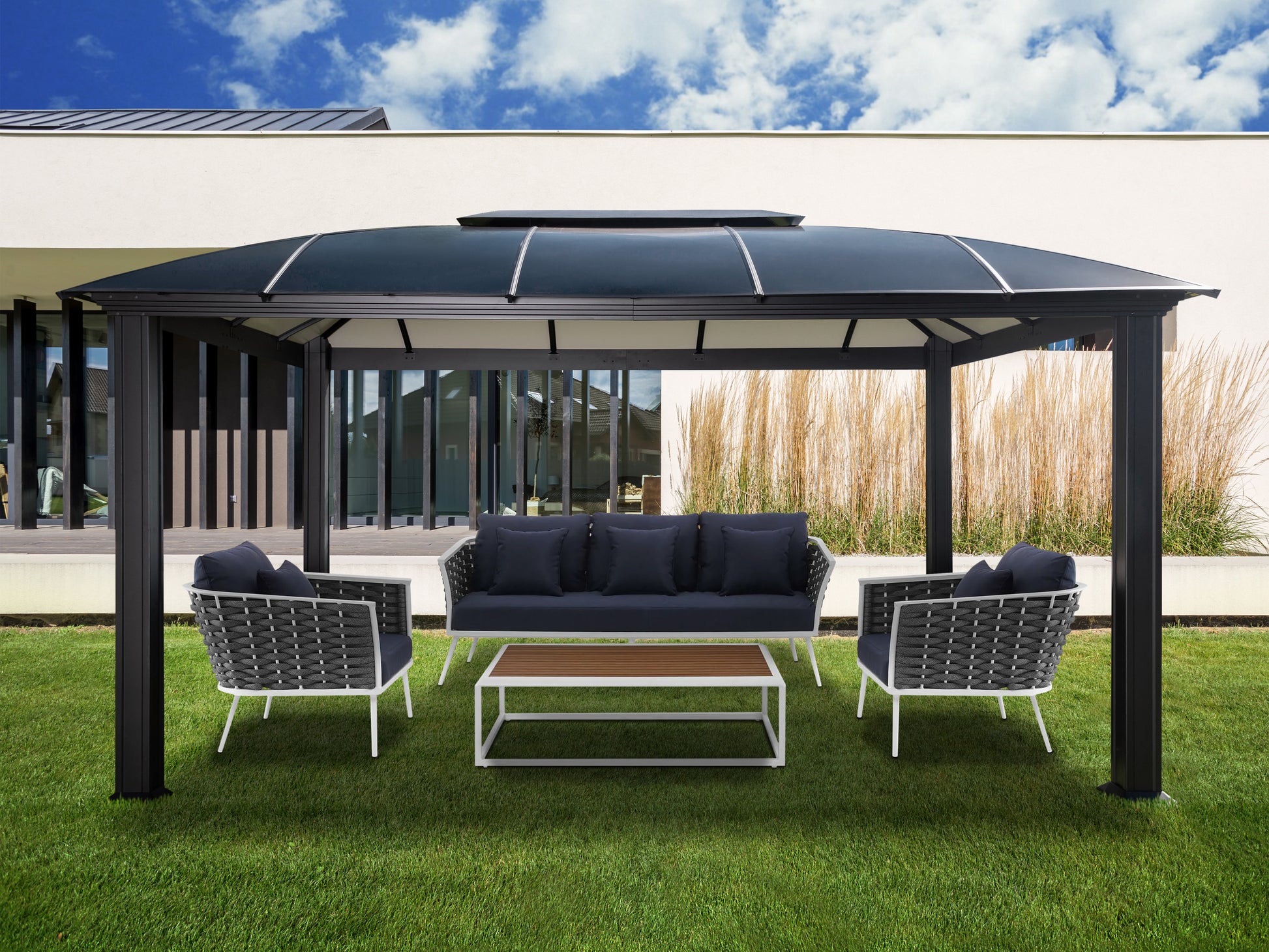 Cambridge Hard Top Gazebo on lawn behind a modern house and stylish navy and white patio furniture underneath.