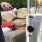 Close up of the Illume Patio Heater in Stainless Steel. Model is close to heater with remote control.