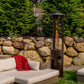 Shine Propane Patio Heater in Hammered Bronze in lush backyard with neutral outdoor couch and chairs.