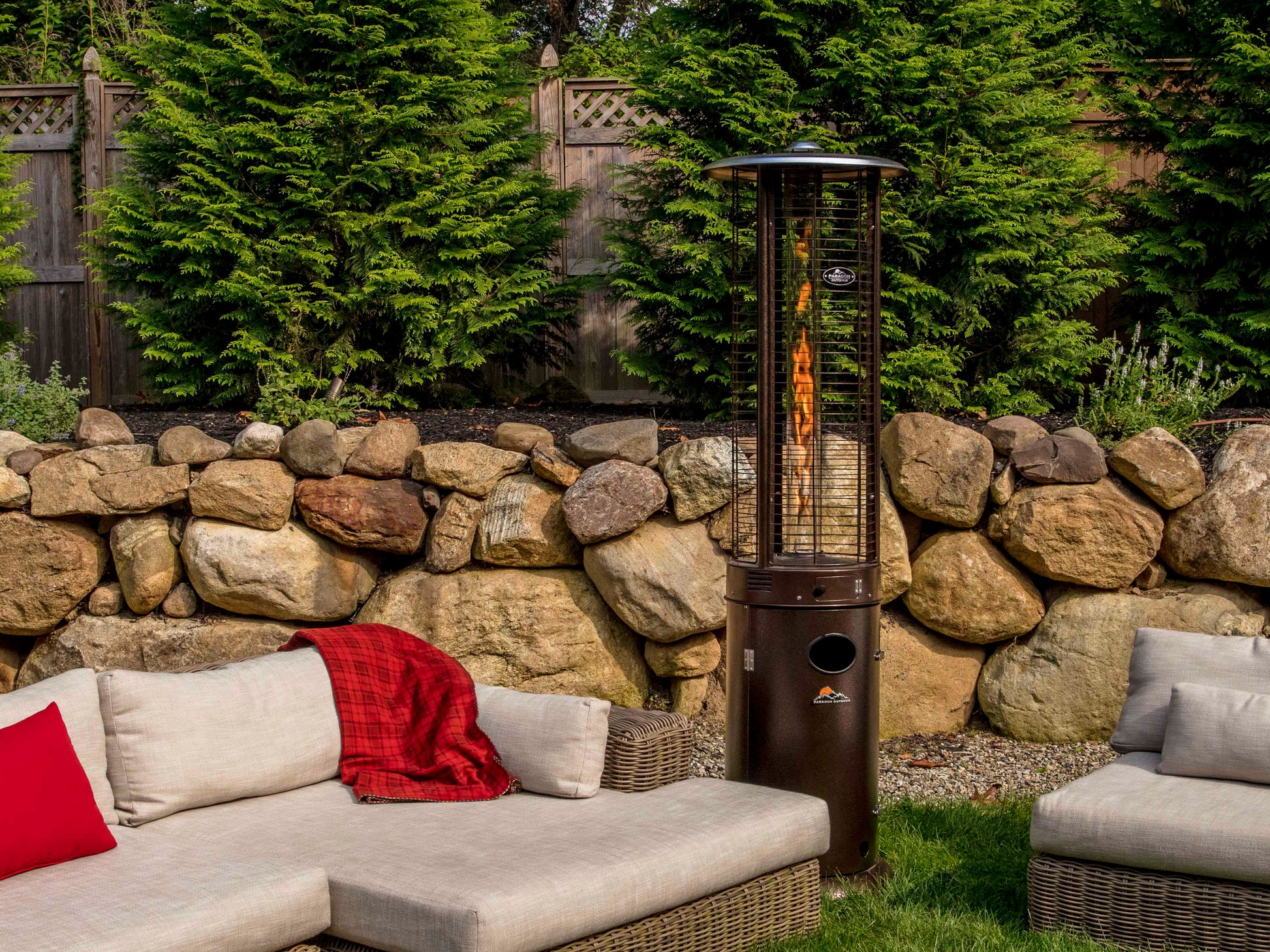 Shine Propane Patio Heater in Hammered Bronze in lush backyard with neutral outdoor couch and chairs.
