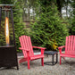 Boost Propane Patio Heater in backyard with red Adirondack chairs in lush backyard